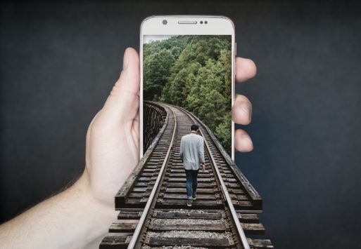 A smartphone showing someone walking down a railroad track shows how technology and mourning intersect