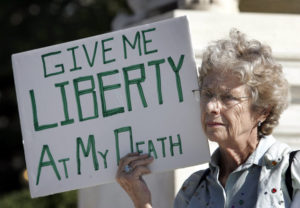 Elderly woman holding a sign in film "Departing: Death and the Art of Dying"