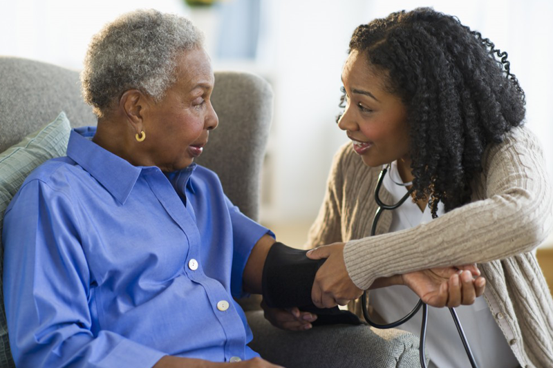 Young caregiver checking mother's blood pressure may be eligible for a tax credit soon