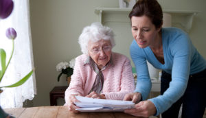 Caregiver and elderly relative looking at medical papers related to a tax credit