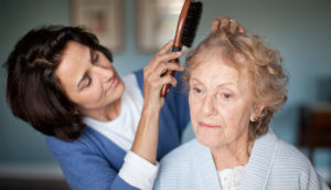 A woman combing her mother's hair needs paid family leave