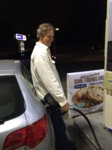 Man at gas pump smiling despite the ripple effect of grief