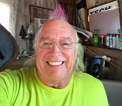 An elderly man with a purple Mohawk is working towards conscious dying