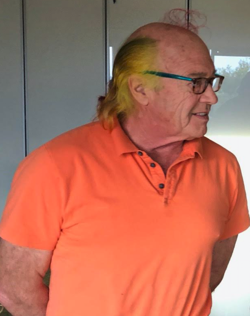 A man in an orange shirt looking ahead at awareness of death