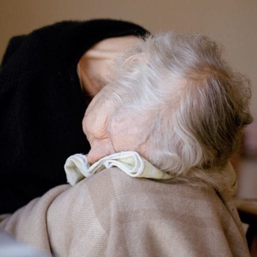 An elderly woman slumped in a chair in hospice provider's care