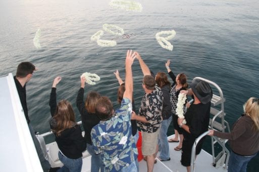 Guests at memorial service scatter ashes from a boat
