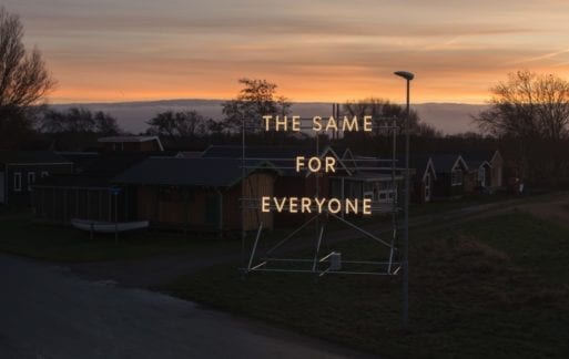 "The Same For Everyone" light installation by Nathan Coley during a sunset.