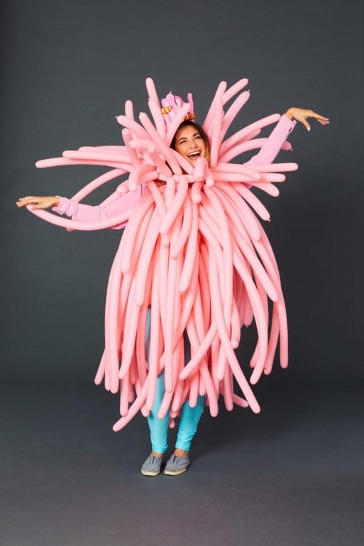 A woman dressed up in a pink flower costume showing imagination at Halloween