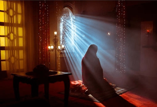 A woman prays following Muslim traditions around death