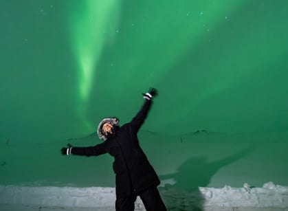 Kaethe Weingarten, expert on critical illness and witnessing violence, stands in front of the Northern Lights