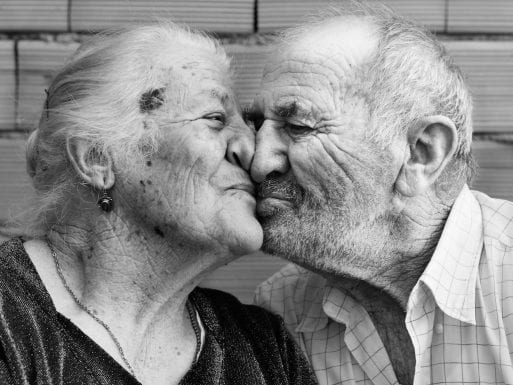An elderly couple kissing in Ogliastra in Sardinia, Italy. 