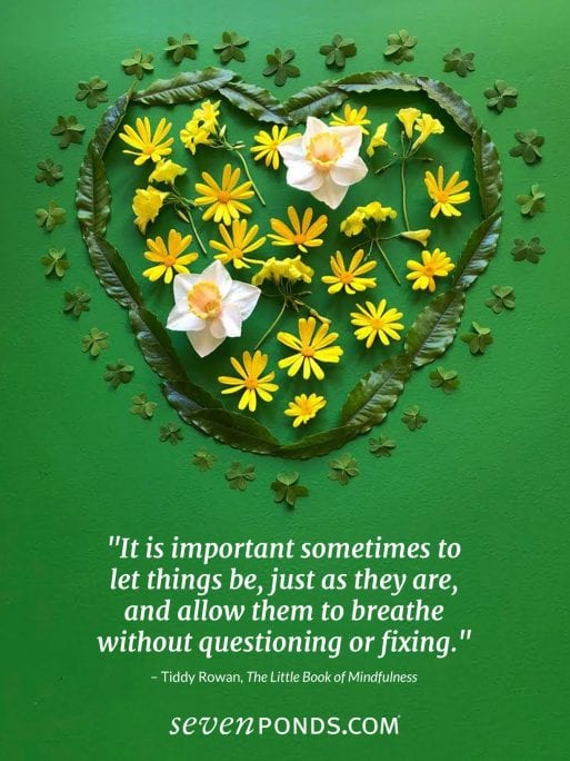 Spring flowers made up a handmade heart and a quote about mindfulness