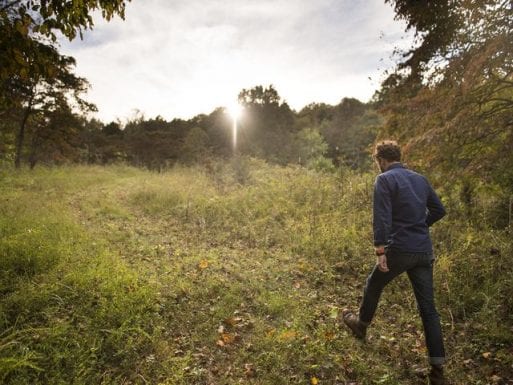 image of a man walking through a conservation burial ground indicating shifting attitudes about death