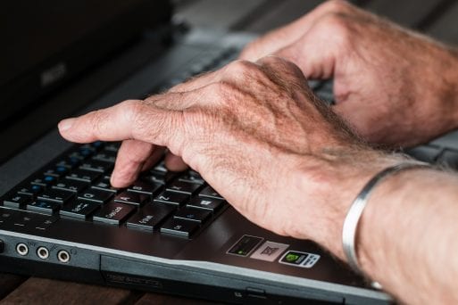 Image of someone researching COVID-19 scams on a computer