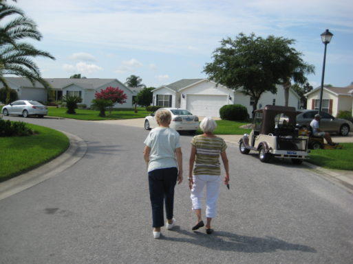 Two women step out for a walk in a suburban neighborhood.