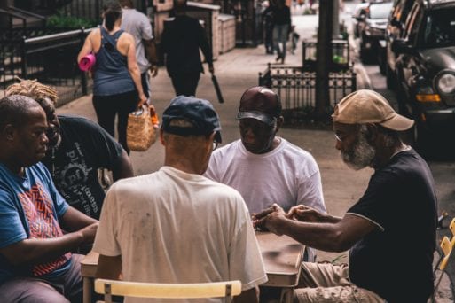 Seniors gather together on a sidewalk for activities.