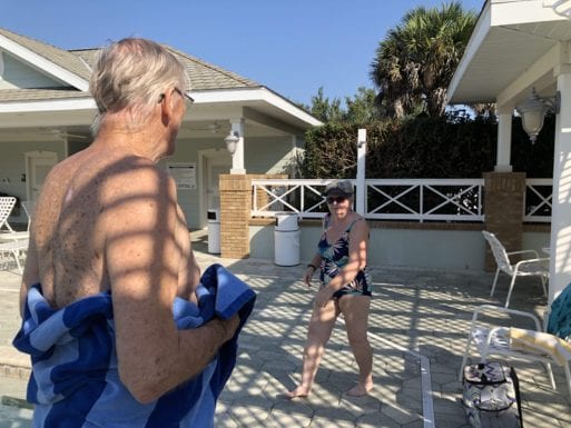 A woman at the poolside with a friend and neighbor after learning his spouse has dementia