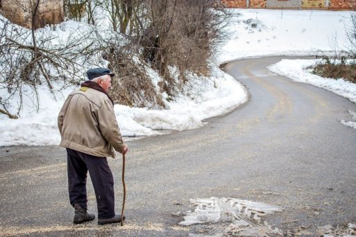 Older man alone on empty road captures feeling of isolation when cancelling holiday plans with older family members