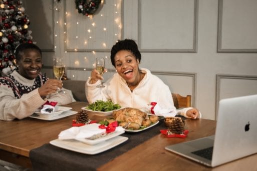A couple connects online with others during Christmas dinner.