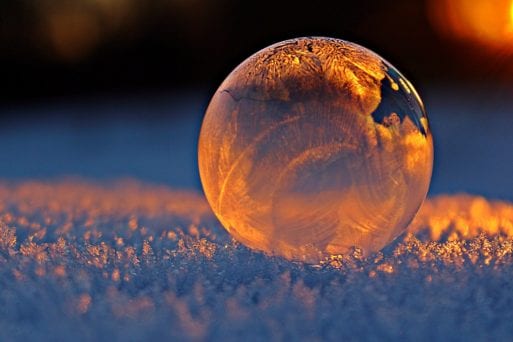A glass ball on a field of ice recalls David Whyte's poem, "Winter Grief."