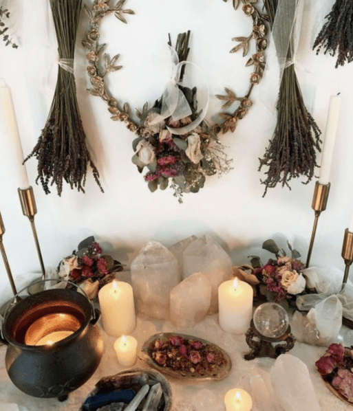 An altar set up with candles and crystals pays homage to someone who died