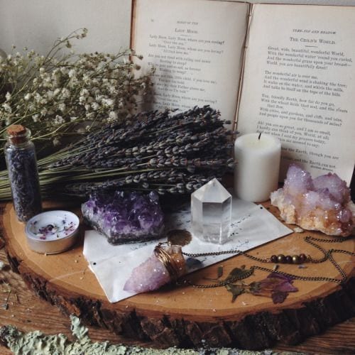 A grief shrine with a candle, crystals and dried flowers 
