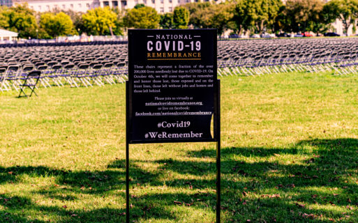 COVID-19 memorial sign in front of field full of folding chairs (national grief strategy)