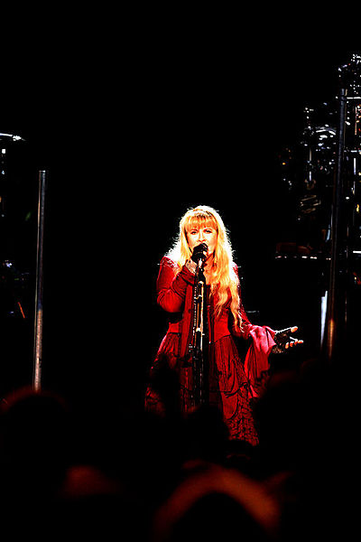 Stevie Nicks onstage in a red dress in 2011