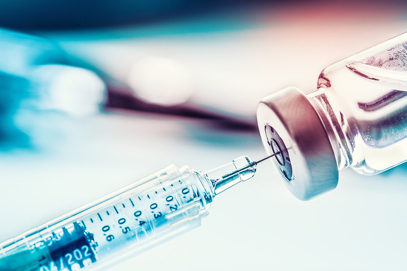 Syringe drawing vaccine from a bottle - vaccines for family caregivers