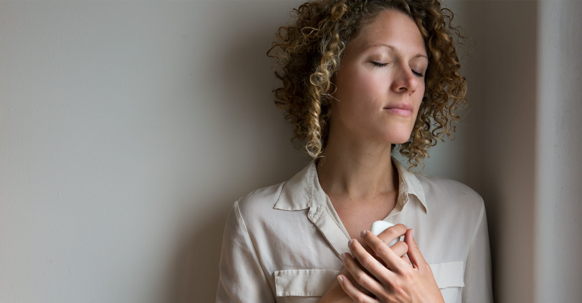 A young woman holds a Parting Stone close.