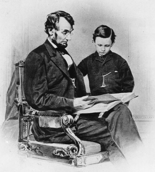Photo of Abraham Lincoln reading with his son Tad - child loss