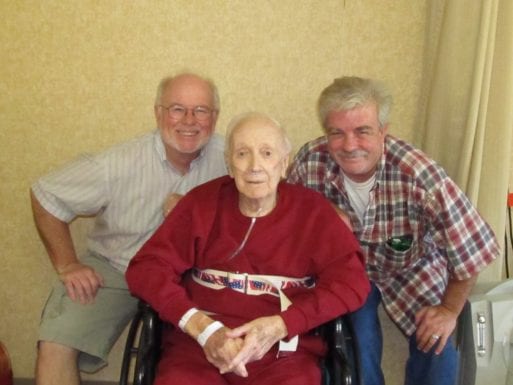 Bates and his brother pose with his father in a wheelchair.
