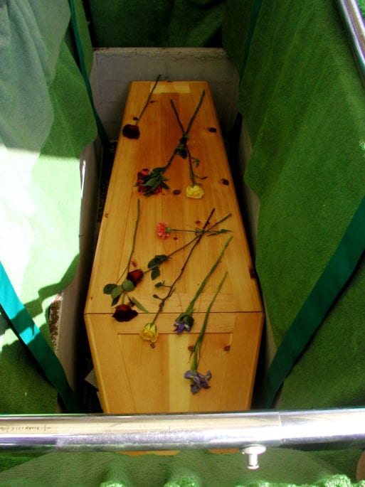 A pine box, strewn with flowers, used for the body transport of Bates' father.