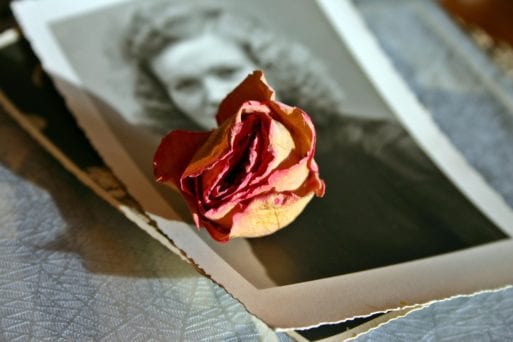 a photo of a loved one who has died with a rose