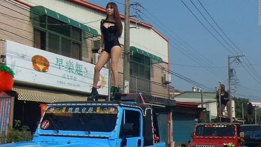 A Taiwanese funeral stripper rides atop a truck.