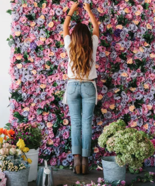 woman assembling wall of flowers