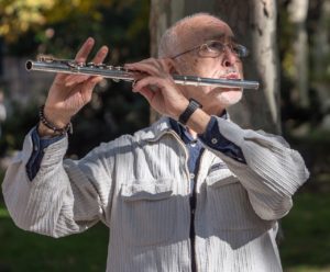 older man playing the flute improving mind