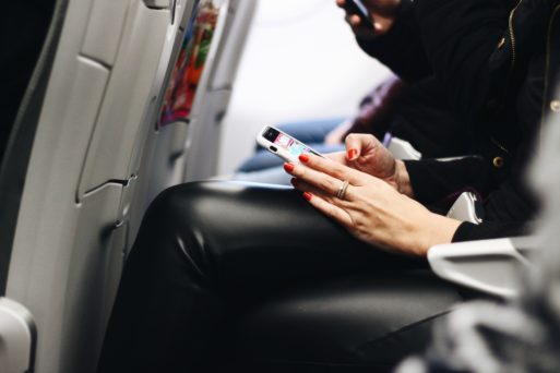 woman holding a cell phone in her lap with smishing scam