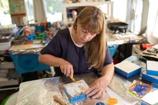 Ingrid Tegner, who offers poetry therapy, working in encaustic.