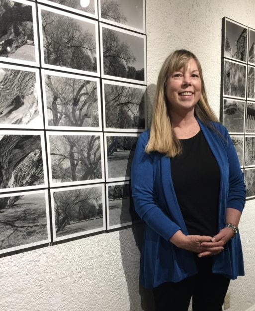 Ingrid Tegner poses next to her photographs of trees.