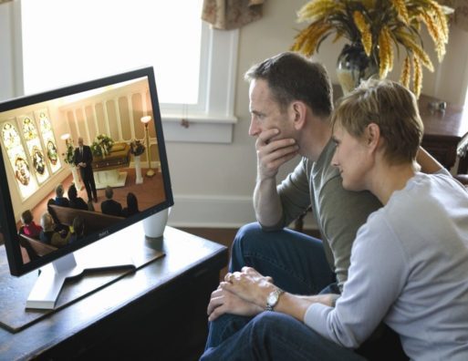 man and woman watching a virtual memorial service before Zoombombing