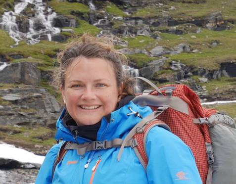 Researcher Alison Klevnäs, who researches reopened graves, poses with a backpack.