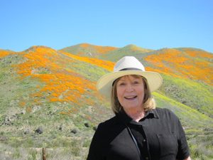 Poet Barbara Crooker poses in front of a dessert landscape.