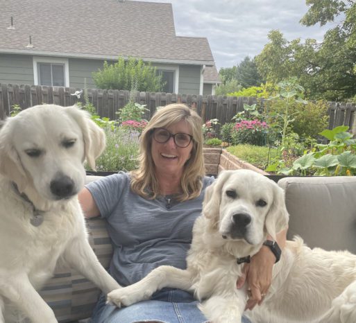 Shannon Yockey poses with her two large, white dogs, one of which participates in sandplay.