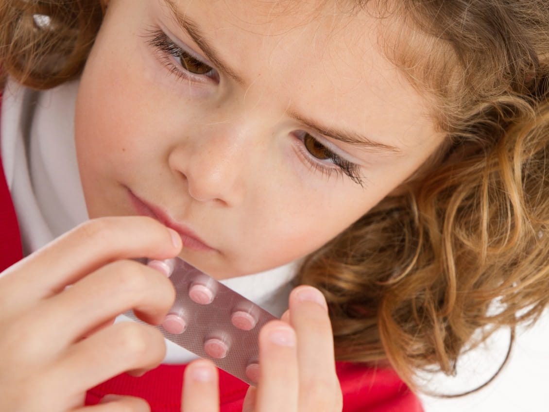 young girl examining melatonin pills