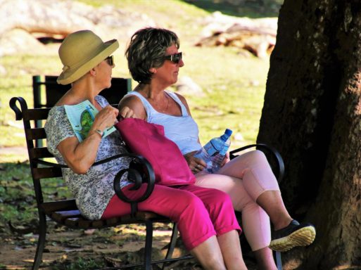 Two elderly women resting on a bench