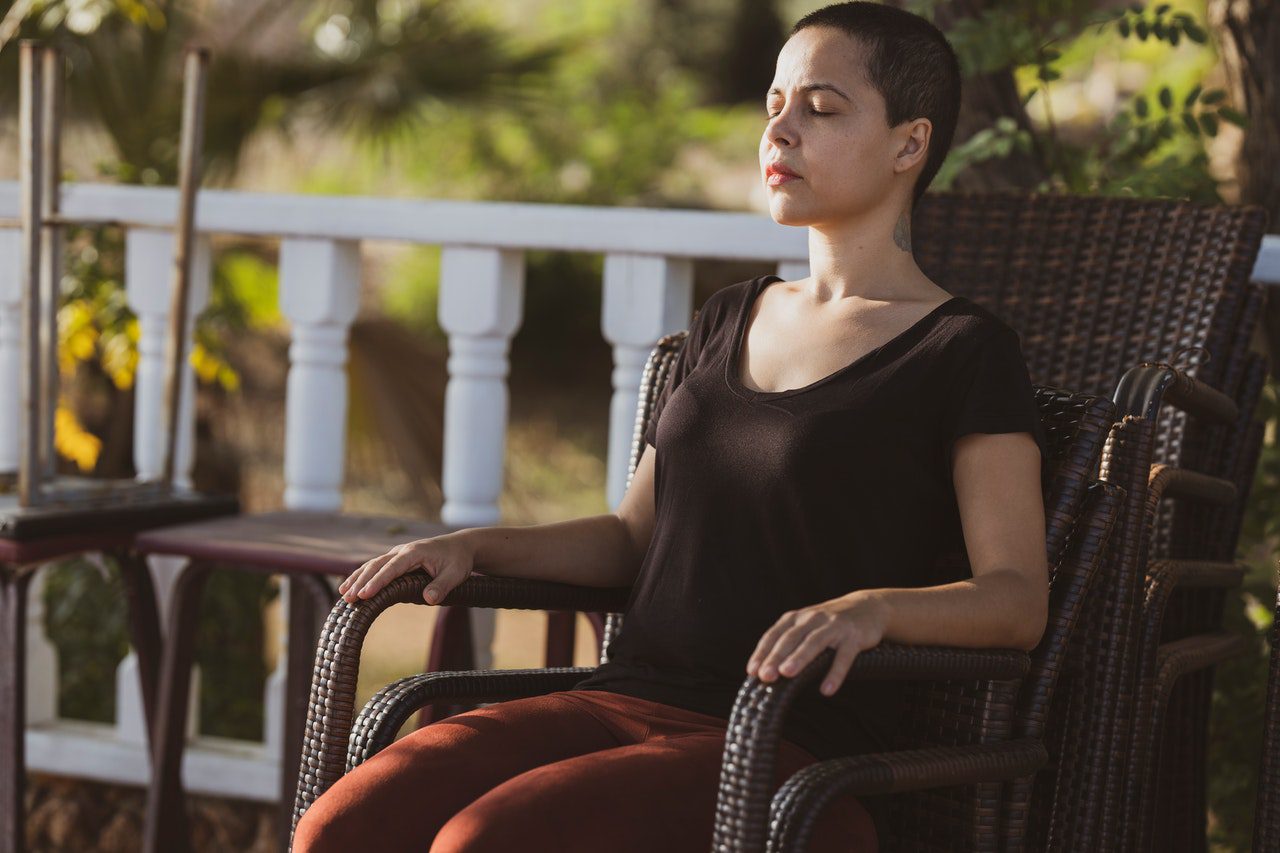 A woman meditates in a chair, which may lead to PTG.