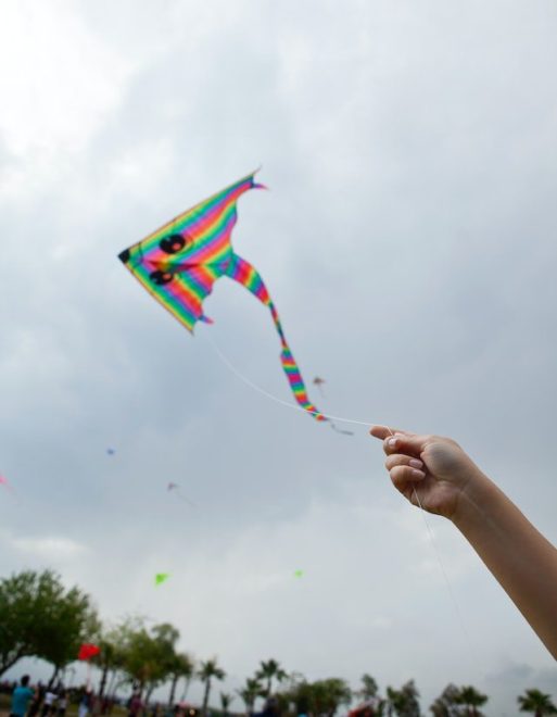 a hand flying a kite at a memorial service