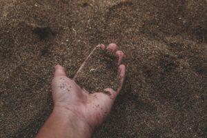 A handful of dirt represents the result of legalizing human composting.