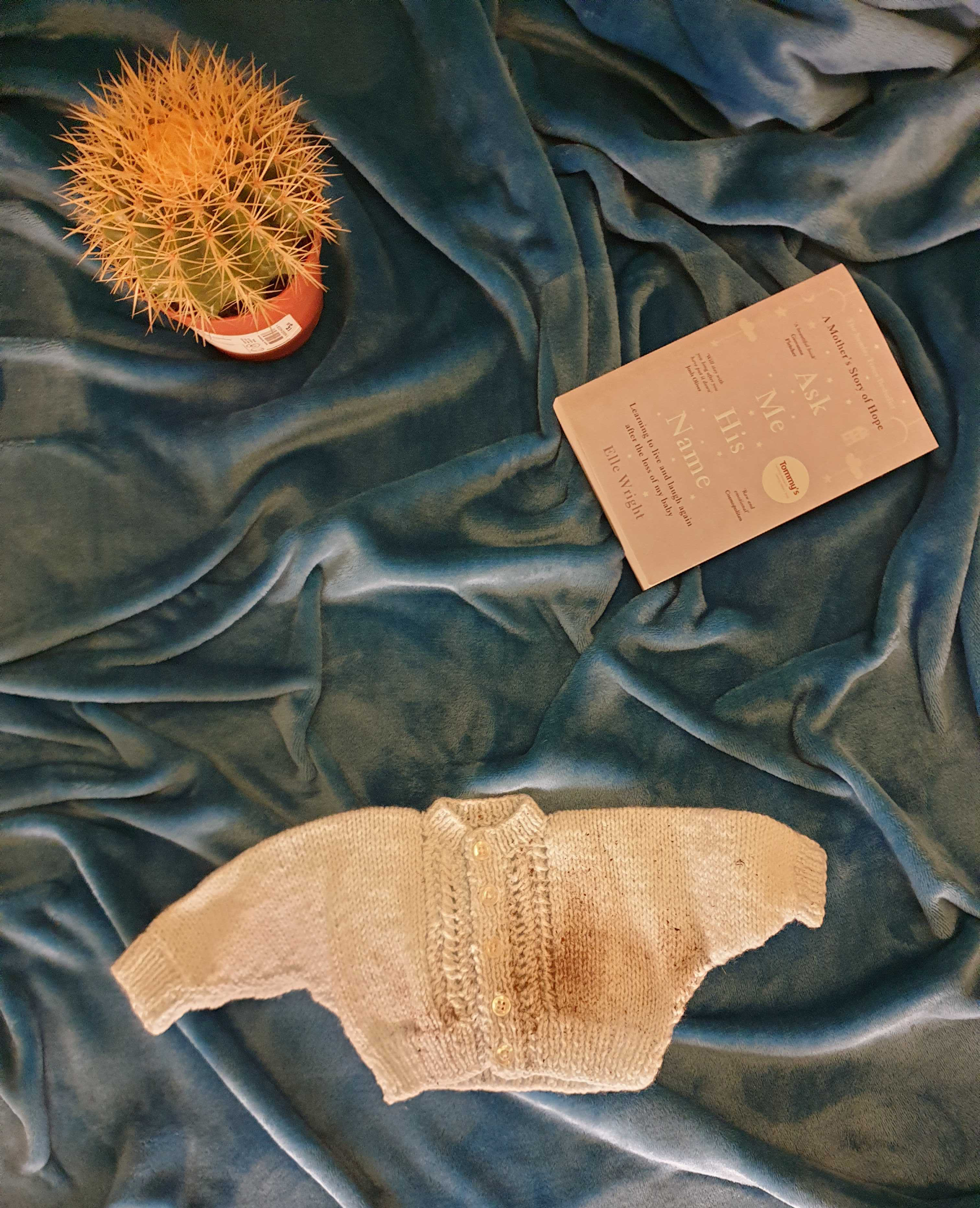 An infant sweater and a card on a cloth background